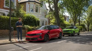 Electric car charging at a roadside EV charger on a leafy UK residential street, with another electric vehicle parked behind